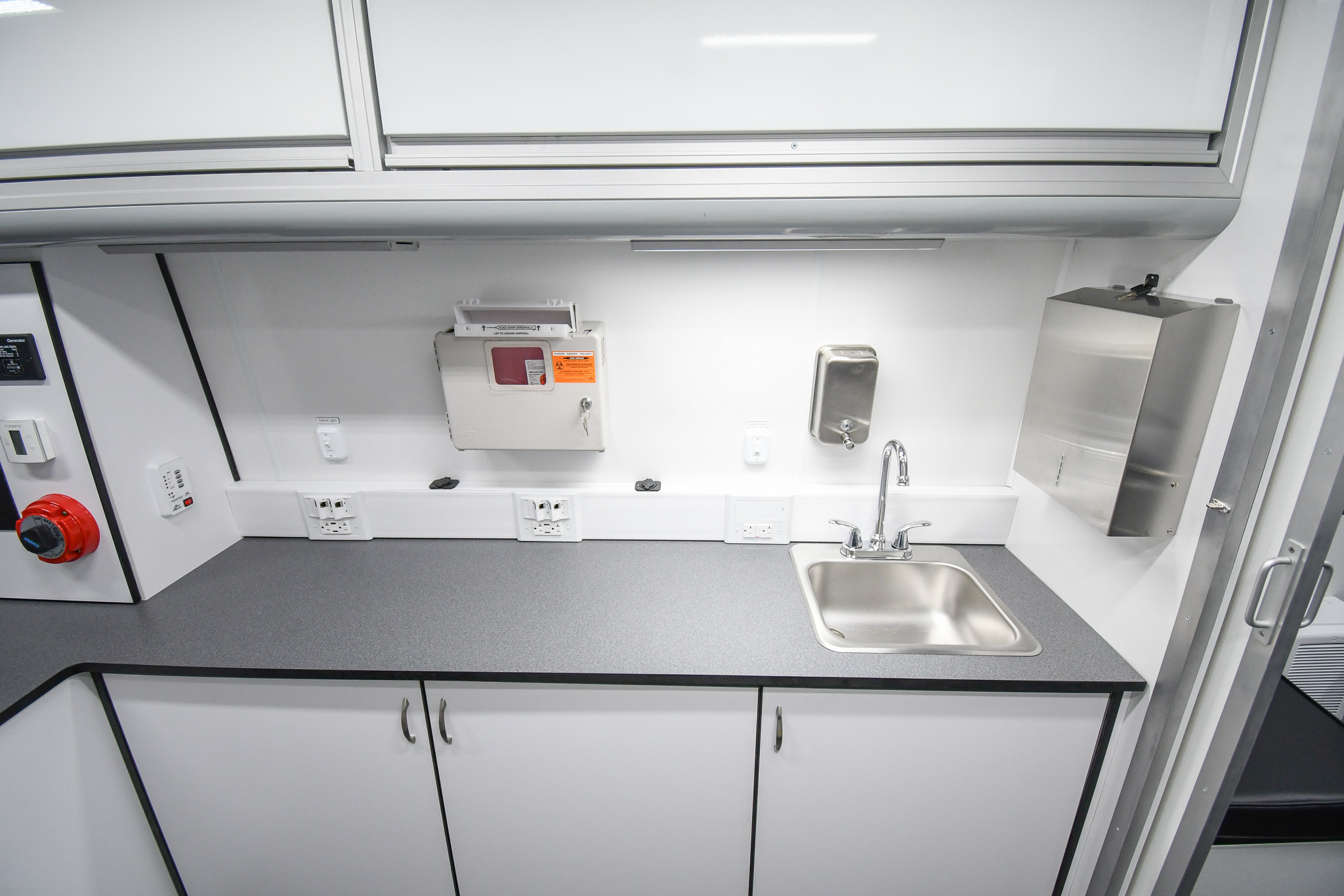 The sink, cabinets, and sharps disposal container inside the unit for Lancaster, PA.