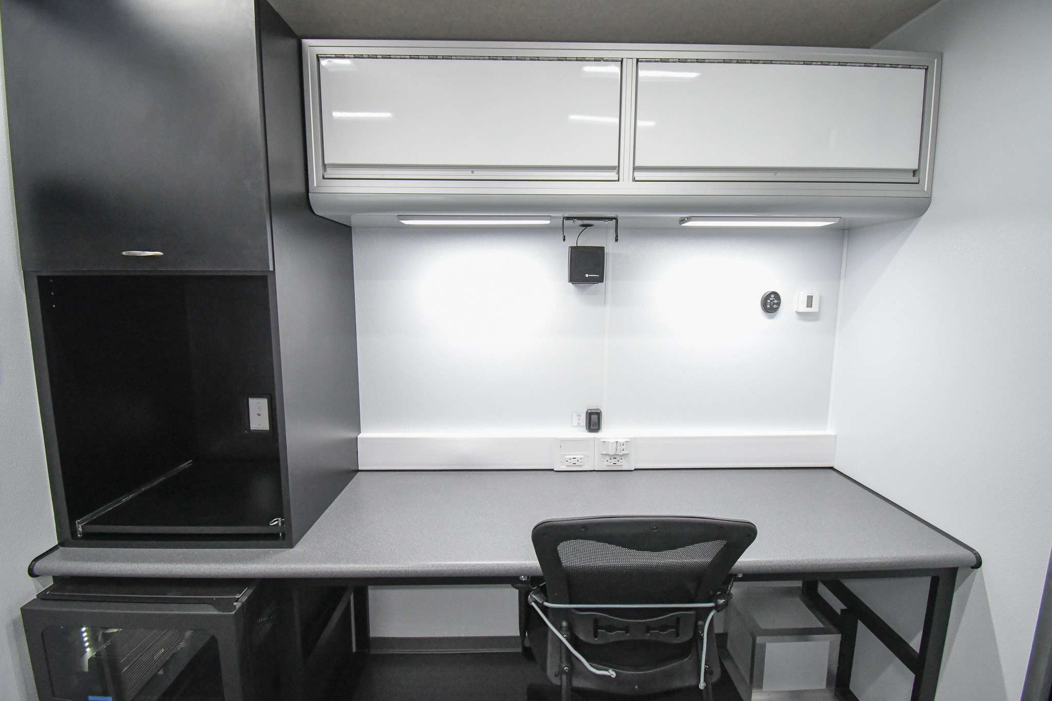 A workstation, electronics rack, and a custom storage cabinet inside the unit for Winchester, VA.