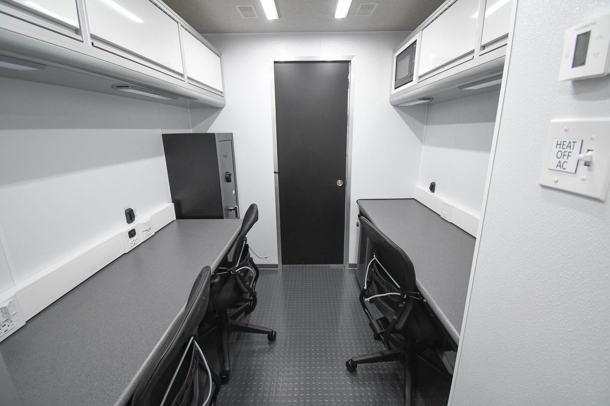 A back-to-front view inside the unit for Columbiana, OH. There are three workstations, a microwave, a refrigerator, and lockable gun closet.